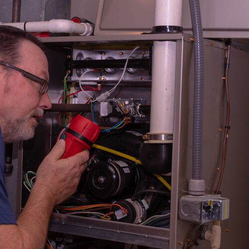 A Technician Checks a Gas Furnace.