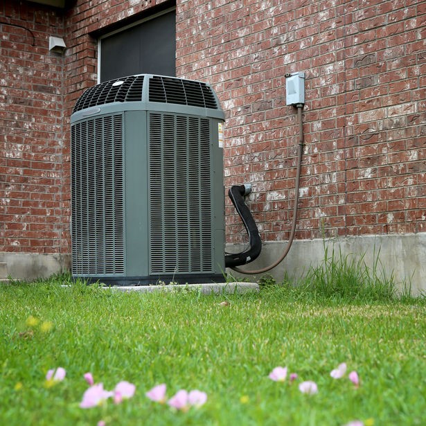 air conditioner system outside near wild flowers